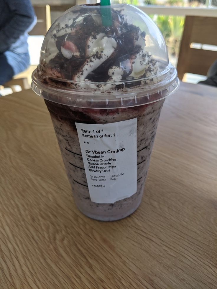 a plastic cup filled with food on top of a wooden table