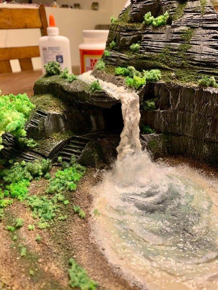 a model waterfall is shown with moss growing on the rocks and water coming out of it