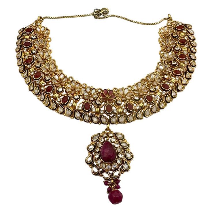 Add a touch of luxuriousness to your look with the Egyptian necklace. This ornate choker features an exquisite handmade design, delicately crafted using color to create a truly unique piece. Wear it day or night for a glamorous finish every time. Egyptian, jeweled necklace ornate with handmade tooling, beads, oval-shaped red, and white-colored stones. The pendant is adjustable for length at 17" and can be reduced for a choker. The wide pattern consists of mesh that extends half of the necklace a Opulent Hand Set Necklace For Gift, Elegant Gold Plated Kundan Necklace For Ceremonial Occasions, Ceremonial Gold Kundan Necklace, Celebration Gold Plated Jeweled Necklaces, Elegant Gold Choker For Festive Occasion, Elegant Kundan Jeweled Necklaces, Traditional Gold Plated Necklaces With Jewels, Elegant Kundan Necklace With Intricate Design For Ceremonial Occasions, Elegant Kundan Necklace With Intricate Design For Ceremonies