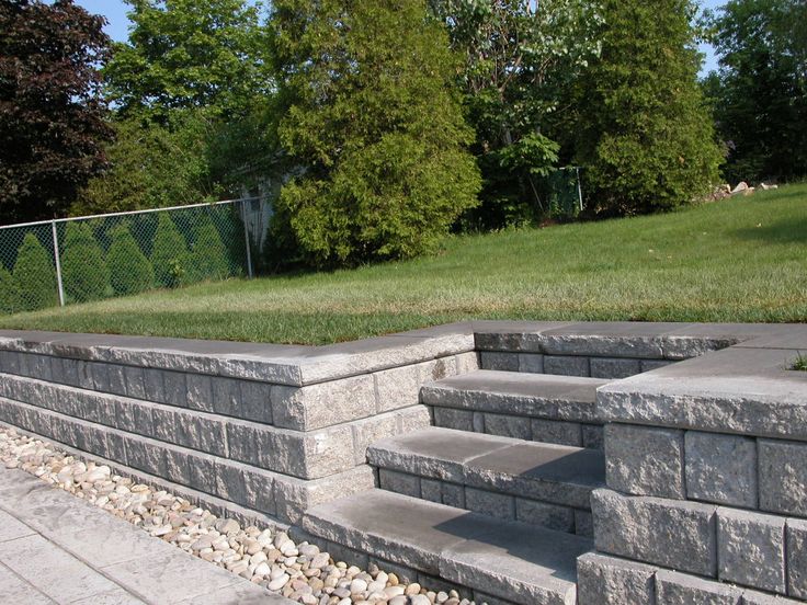 some steps that are made out of concrete and gravel in front of a grassy area