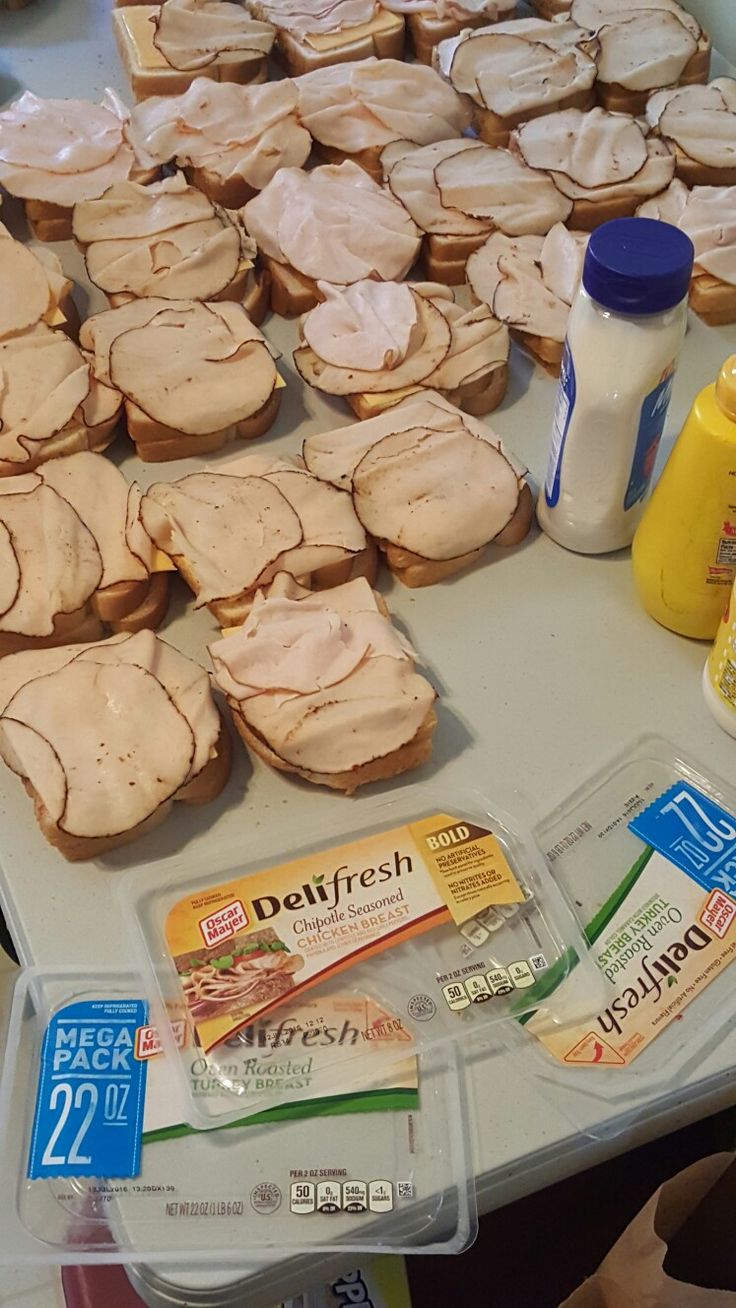 a table topped with lots of sandwiches and condiments