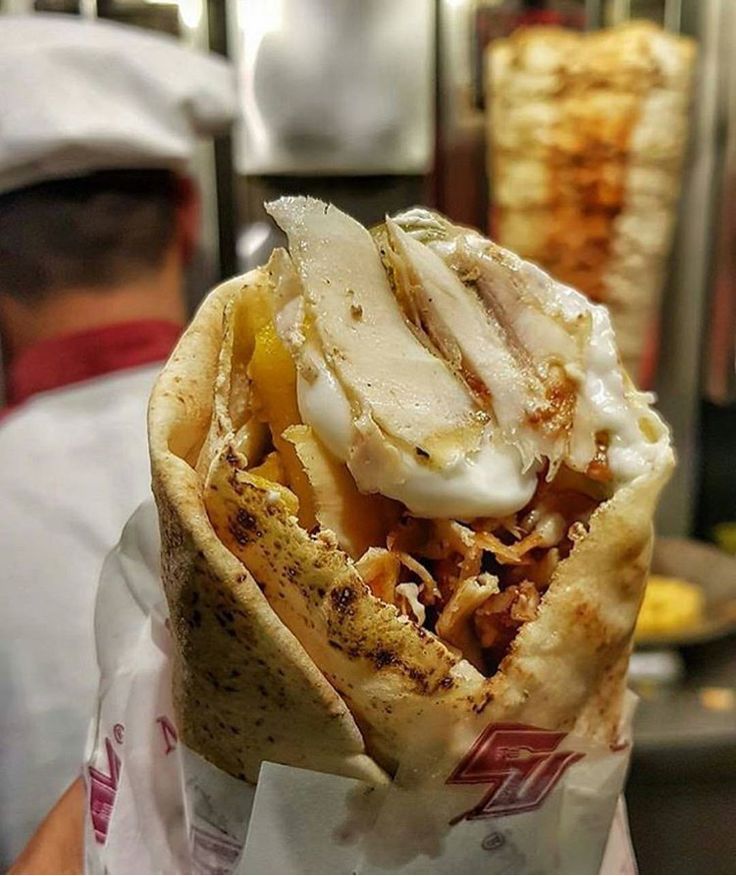 a close up of a burrito wrapped in paper