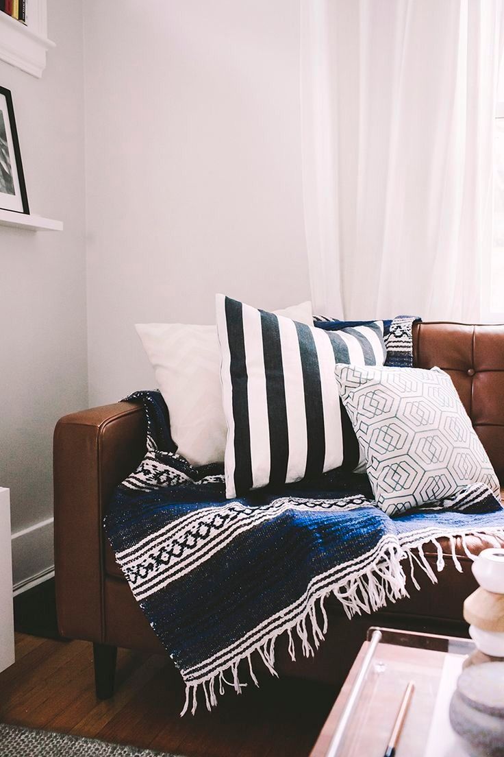 a living room with a brown couch and white curtains on the window sill that says deep blue love