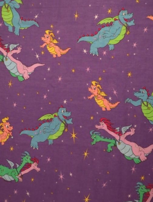 purple fabric with green and pink dinosaurs flying through the air on stars in the sky