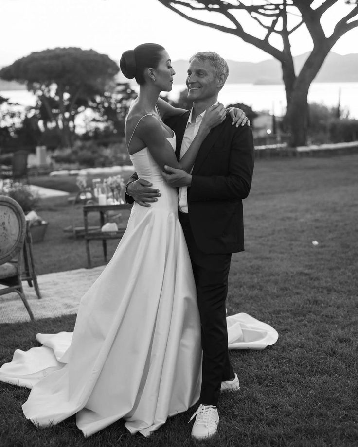 a man and woman standing next to each other in the grass