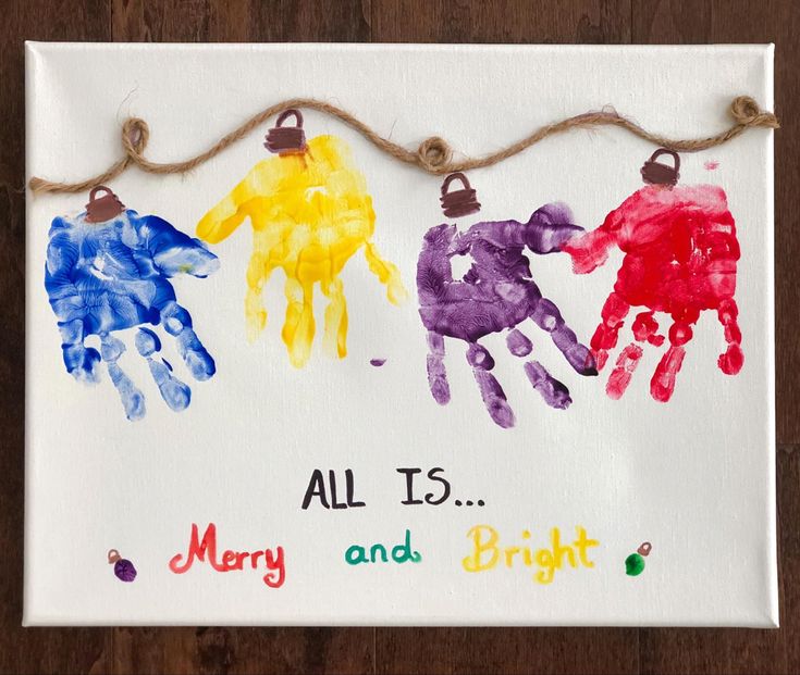 three handprints are hung on a string with the words, all is merry and bright