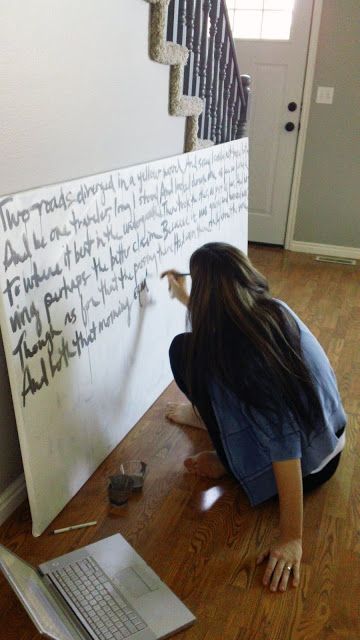 a woman writing on a white board next to a laptop computer and stair railings