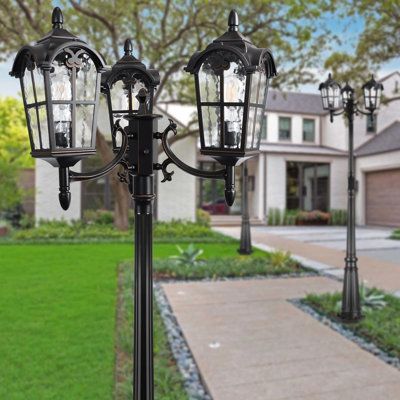 two black street lamps in front of a house