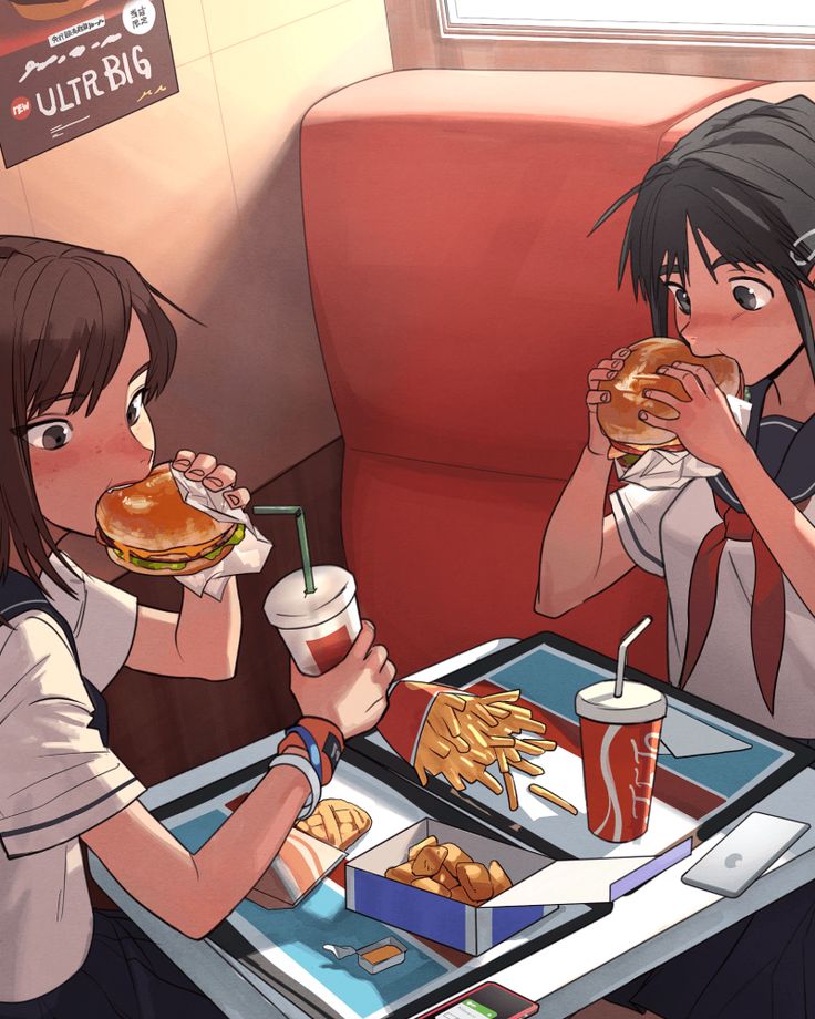 two people sitting at a table eating food and drinking sodas in front of them