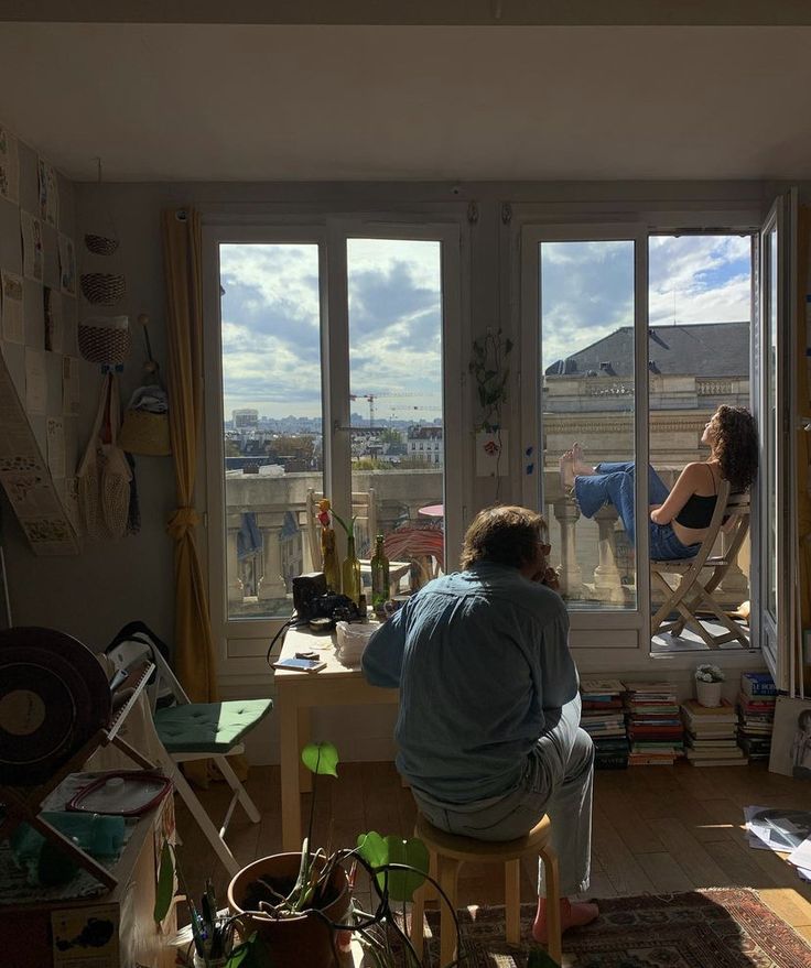 a person sitting in a chair looking out the window