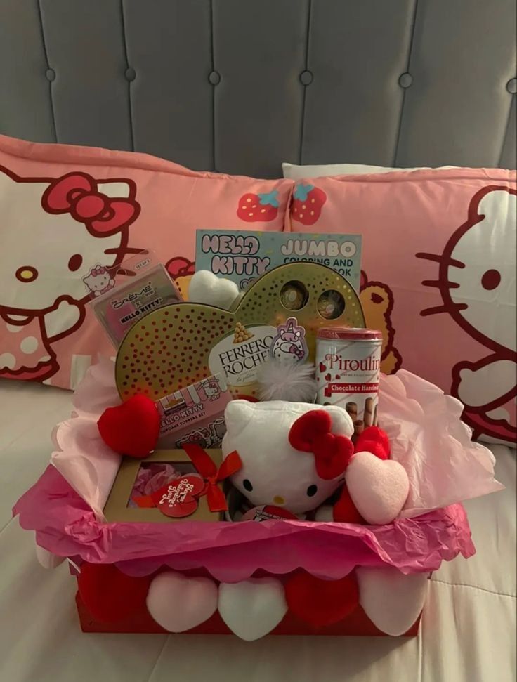 a hello kitty gift basket on top of a bed in a room with pink and white pillows