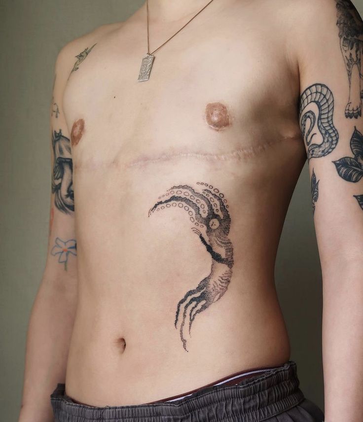 a man with tattoos on his stomach and chest