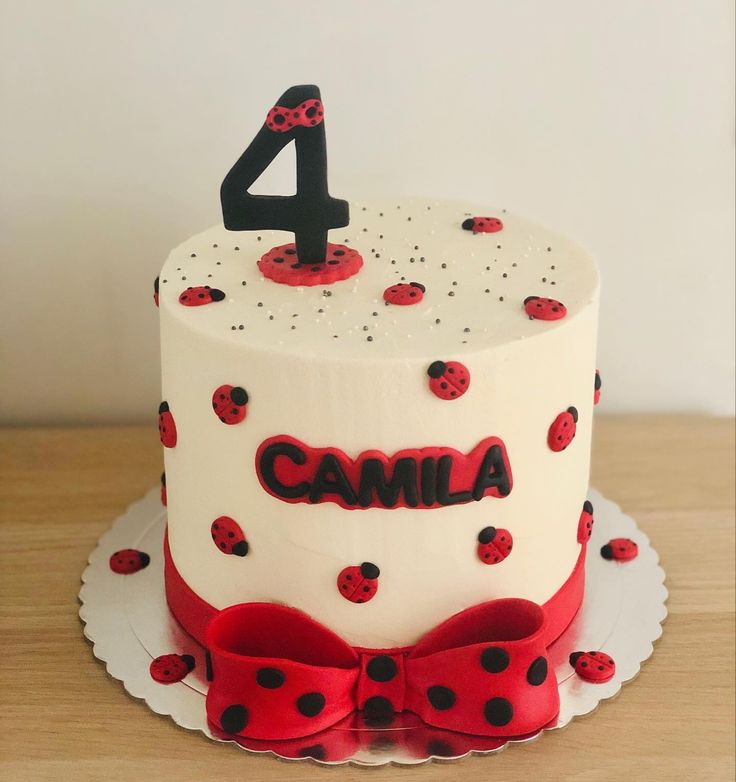 a birthday cake with ladybugs on it and the number four in the middle