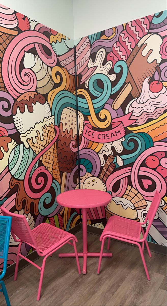 two chairs and a table in front of a wall with ice cream designs on it