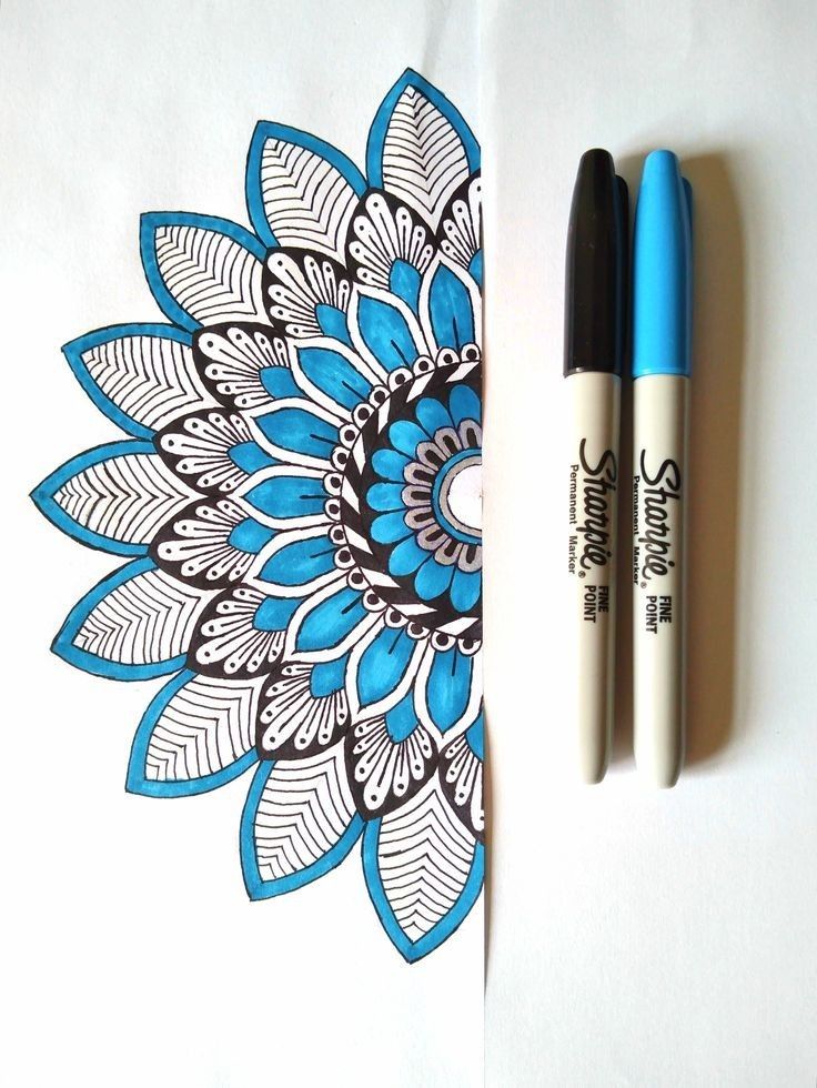 two pens sitting next to each other on top of a piece of paper with a flower design