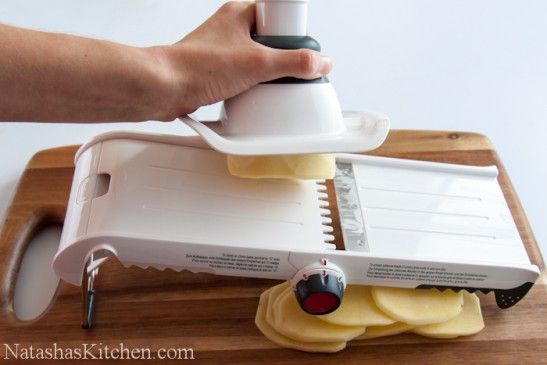 a person is using a slicer to cut cheese