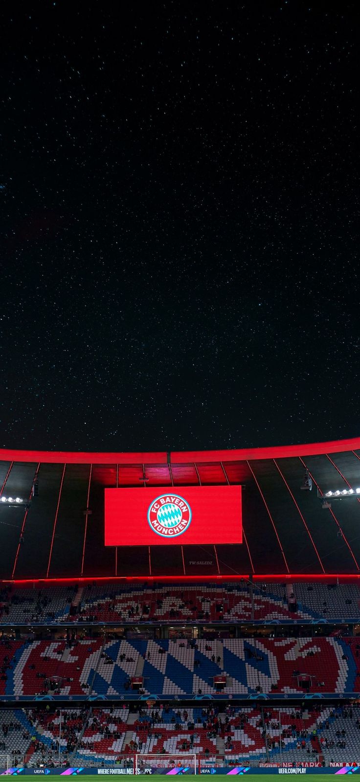 an empty soccer stadium at night with the lights on and stars in the sky above