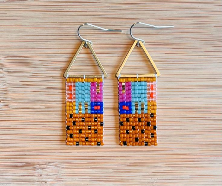 Quilt and textile inspired bars of color, made with glass Miyuki Delica beads, brass toppers, and a 14 K gold plated hypoallergenic ear wire Multicolor Dangling Beaded Brass Earrings, Multicolor Beaded Brass Earrings, Multicolor Brass Beaded Earrings For Festival, Geometric Beaded Gold Earrings, Geometric Gold Beaded Earrings, Gold Beaded Geometric Earrings, Gold Geometric Beaded Earrings As A Gift, Gold Geometric Beaded Earrings, Gold Geometric Beaded Earrings For Gift