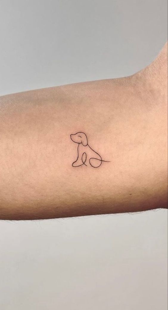 a small dog tattoo on the left forearm and arm, with a line drawing of a dog