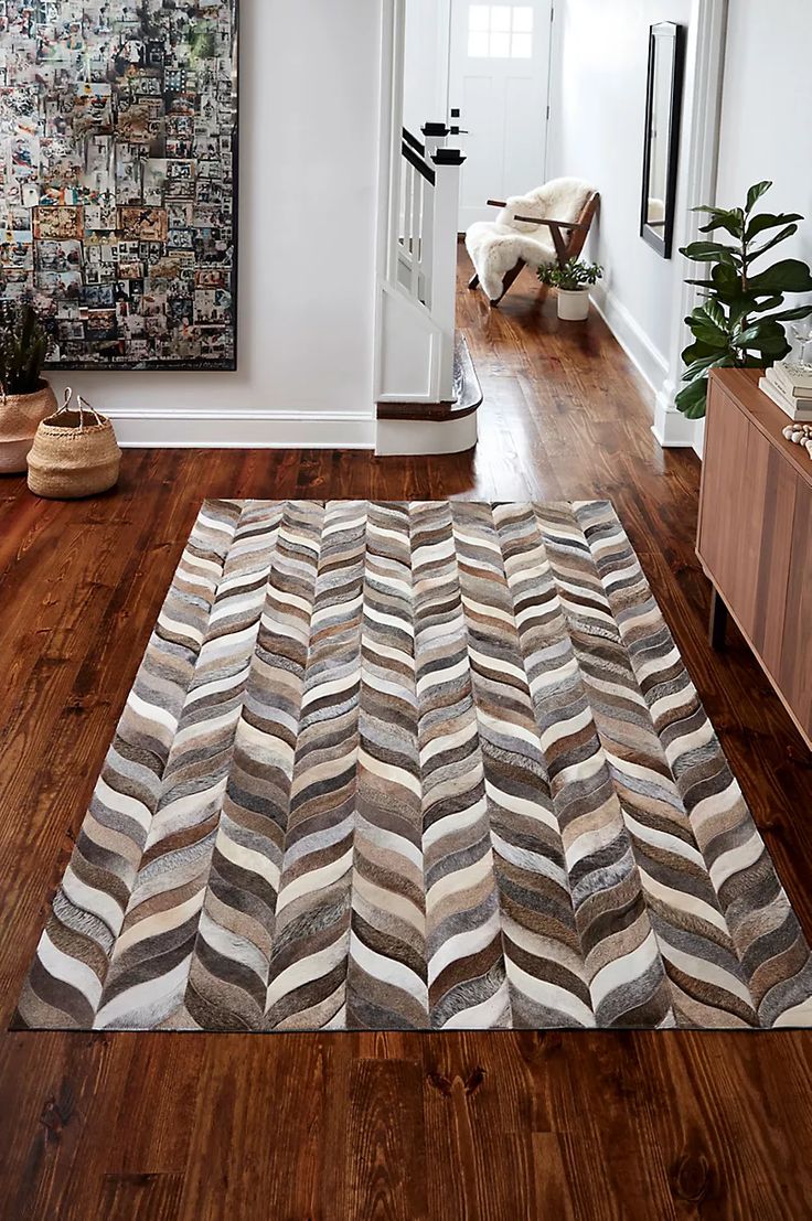 a living room with wood flooring and white walls on the wall is decorated with art