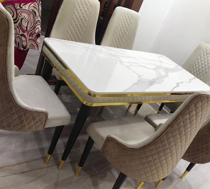 a marble dining table surrounded by beige chairs