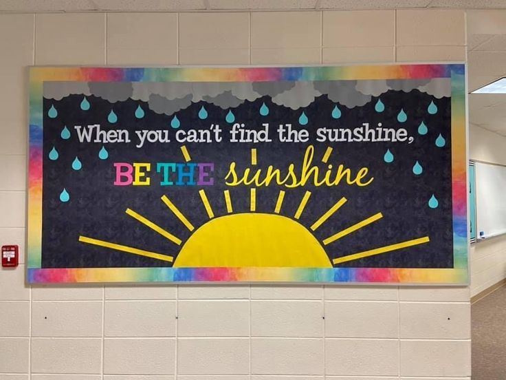 there is a large poster on the wall in an office building that says, when you can't find the sunshine, be the sunshine