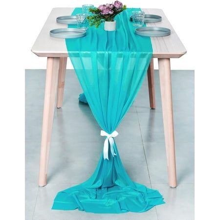 the table is set with plates and cups on it, along with a blue drape