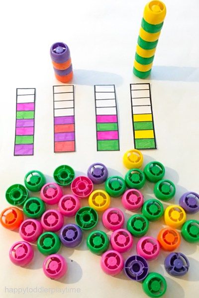 some colorful plastic objects sitting on top of a white table next to a roll of tape