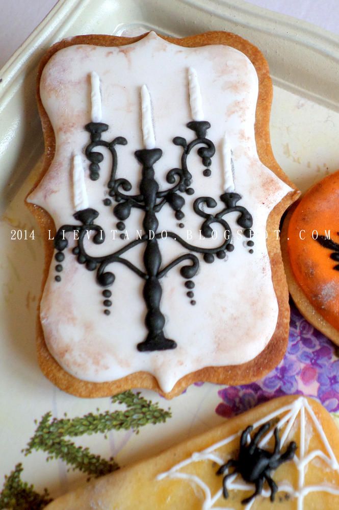 decorated cookies on a plate with candles and spooky decorations