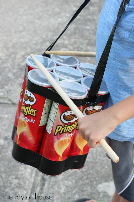 a person holding a basket full of drinks and sticks in their hand while walking down the street