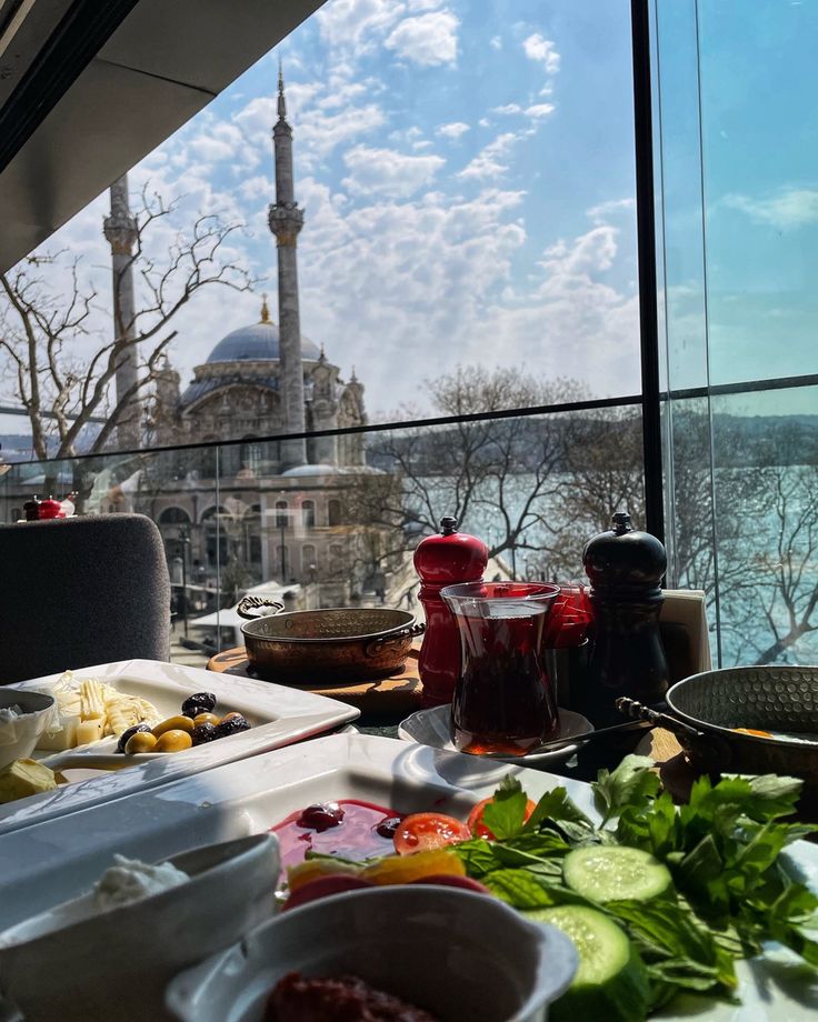 a table with food on it in front of a window overlooking a cityscape