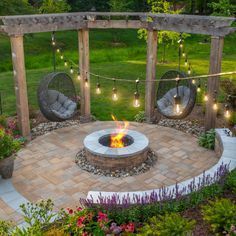 an outdoor fire pit surrounded by plants and lights