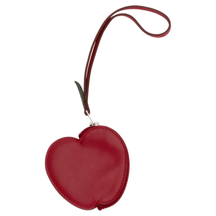 The Hermes Tadelakt Tutti Frutti Pomme Coin Purse Wristlet in Rouge Vif is a small bag charm also doubles as a wristlet coin purse. This apple shaped coin purse is is made from bright red calfskin, the zipper handle features a canopee green leaf tab. Date stamp X. Coin Purse With Wrist Strap Pouch For Gift, Pouch Coin Purse With Wrist Strap For Gift, Gift Coin Purse With Wrist Strap, Wallets With Detachable Strap And Pouch Shape, Pouch Wallet With Detachable Strap As Gift, Wallet With Detachable Strap And Pouch Shape As Gift, Date Stamp, Apple Shaped, Tutti Frutti