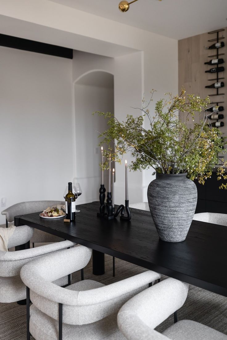 a dining room table with chairs and a vase filled with flowers