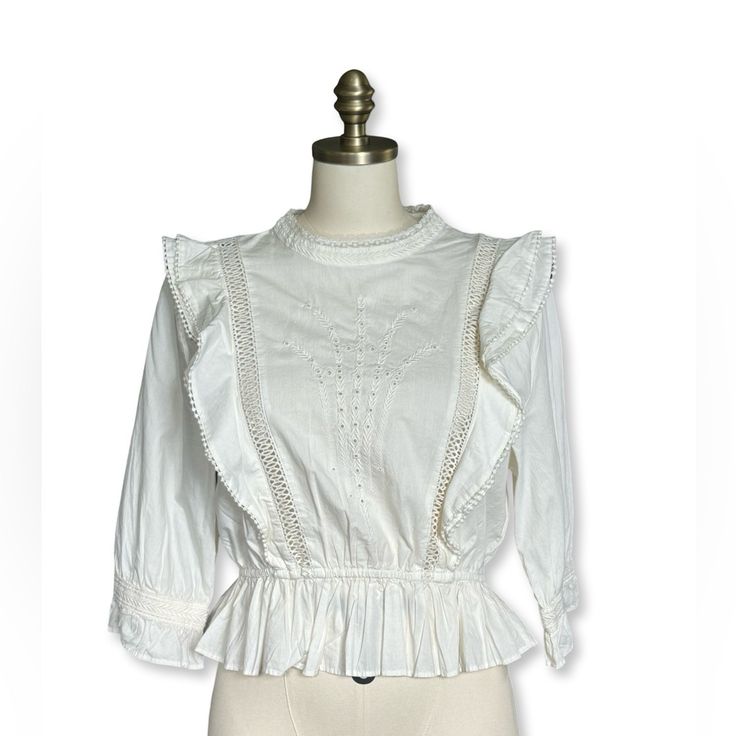 This Is An Embroidered, Crew-Neck Blouse With A Flattering Elasticated Waist, Cascading Ruffle Detailing And Lace Inserts. Beautiful Embroidery Is Placed On The Front And Back Of This Blouse Never Worn/Excellent Condition 100% Cotton Please Let Me Know If You Have Any Questions And Feel Free To Make An Offer! Feminine Cream Ruffled Blouse, Brunch V-neck Blouse With Ruched Details, Feminine Smocked V-neck Blouse, Aritzia Blouse, Aritzia Tempest Blouse, Feminine Off-white Blouse With Ruffles, Tie Front Blouse, Lace Insert, White Halter Maxi Dress