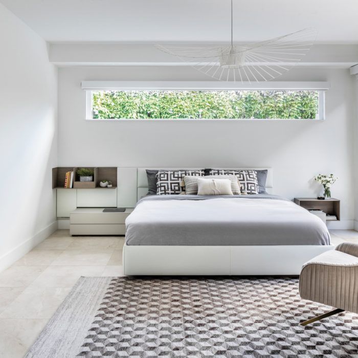 a bedroom with a large bed and white walls