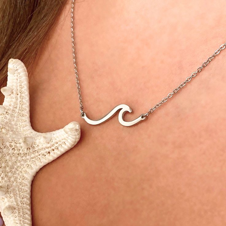 Dive into the enchanting allure of our striking Wave Necklace, where simplicity meets profound meaning. This exquisite piece serves as a daily reminder to appreciate the breathtaking beauty that surrounds us, encouraging a mindful perspective on life. Crafted with meticulous attention to detail, the Wave Necklace is more than jewelry—it's a wearable philosophy, symbolizing the ebb and flow of existence. Gift this elegant keepsake to your cherished beach lover or indulge in the beauty of self-exp Adjustable White Gold Jewelry For Everyday Wear, Adjustable Stainless Steel Jewelry With Delicate Chain, Sterling Silver Clavicle Chain Jewelry As Gift For Mom, Adjustable Clavicle Chain Jewelry For Gift, Adjustable Clavicle Chain Jewelry As A Gift, Adjustable Collar Necklace Jewelry As Gift, White Gold Necklace With Si Clarity As A Gift, Everyday Meaningful Jewelry With Round Pendant, Meaningful Everyday Jewelry With Round Pendant