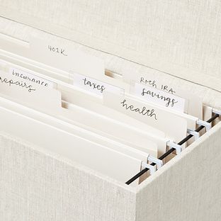 three file folders with labels on them sitting in a linen box next to each other