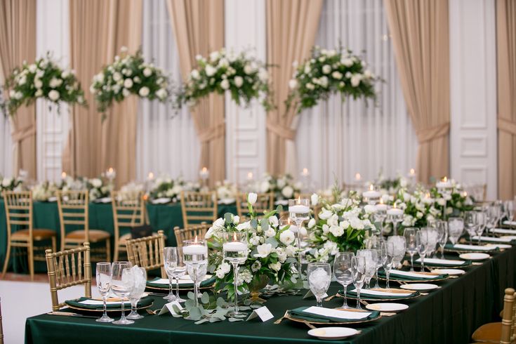 the tables are set with green linens and white flowers