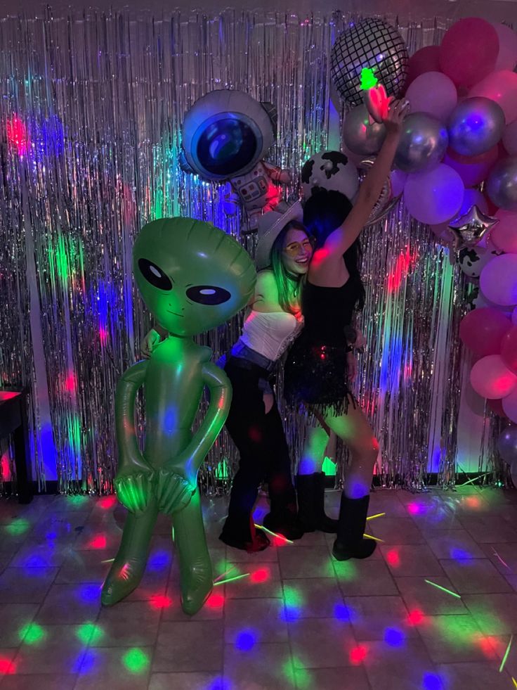 two people standing next to each other in front of balloons