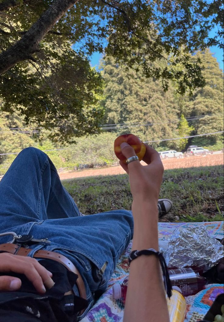 a person laying in a hammock under a tree with their feet on the ground