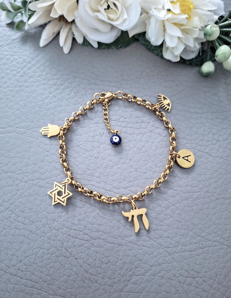 This is our beautiful personalised Jewish Braceler with Chai, Hamsa, Star of David, Lucky Eye and initial letter charms. It Makes a beautiful and thoughtful gift for your loved ones. Materials are 18k gold plated over Stainless Steel, it's hypoallergenic, waterproof and tarnish resistant.   All our items are custom made, it takes 3-5 days to get your order prepared.  The delivery date will depend on your location.  * USA - 2 - 4 weeks * Canada - 2 - 5 weeks * Europe - 2-3 weeks * Other - 2 - 4 w Judaica Jewelry, Letter Charms, Star Of David, Ear Jewelry, Charm Bracelets, Jewelry Stores, Thoughtful Gifts, Favorite Jewelry, Etsy Accessories