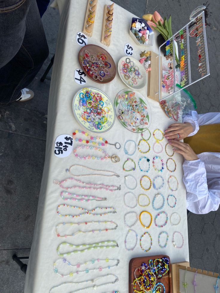 a table topped with lots of different types of bracelets and necklaces on it