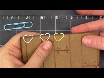 someone is making some paper clips out of crafting material and then cutting them into hearts