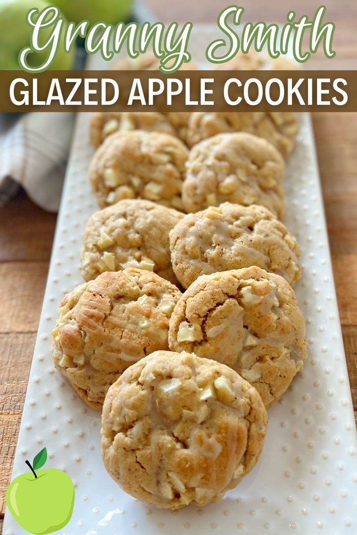 some cookies are on a white plate with an apple in the background