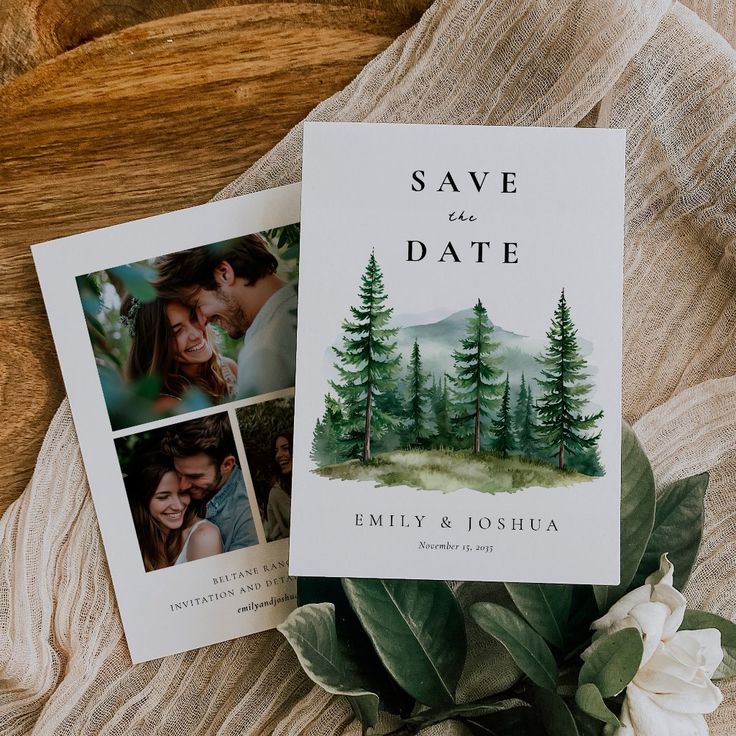 two save the dates cards sitting on top of a table next to flowers and greenery