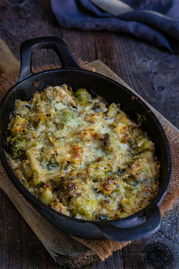 a casserole with broccoli and cheese in a black pan on a wooden table