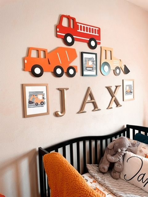 a baby's room with cars and trucks on the wall, including a crib