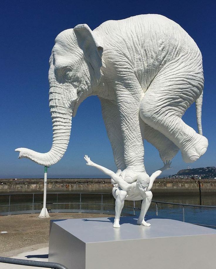 an elephant statue with its trunk in the air and it's legs spread out