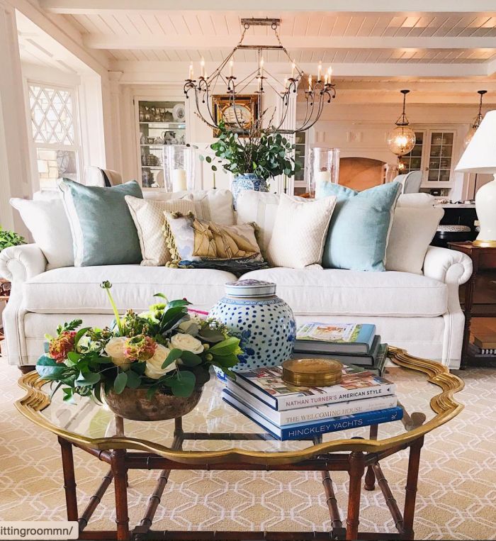 a living room filled with lots of furniture and flowers on top of a coffee table